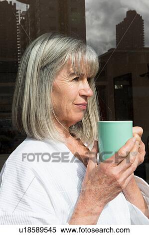 Woman with mug beside window View Large Photo Image Stock Photography - Woman with mug beside window. Fotosearch