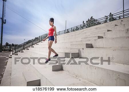 Young female runner moving down stairway View Large Photo Image Stock Photo - Young female runner moving down stairway. Fotosearch