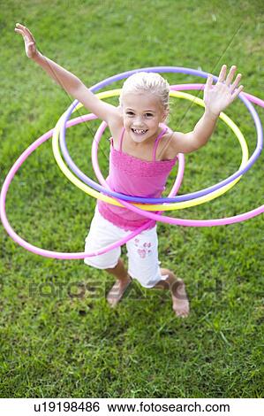 Young girl hula-hooping View Large Photo Image Stock Photograph - Young girl hula-hooping. Fotosearch