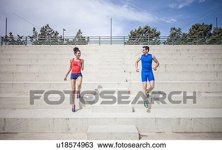 Young male and female runners moving down stairway View Large Photo Image Stock Image - Young male and female runners moving down stairway. Fotosearch