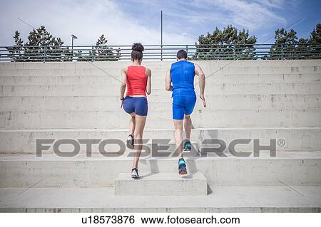 Young male and female runners running up stairway View Large Photo Image Stock Photograph - Young male and female runners running up stairway. Fotosearch
