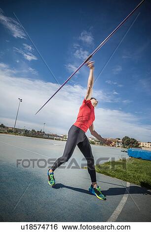 Young man throwing javelin in sports ground View Large Photo Image Stock Photograph - Young man throwing javelin in sports ground. Fotosearch