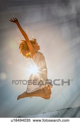 Young woman jumping mid air at sunset on Miami Beach, Florida, USA View Large Photo Image Stock Photography - Young woman jumping mid air at sunset on Miami Beach, Florida, USA. Fotosearch