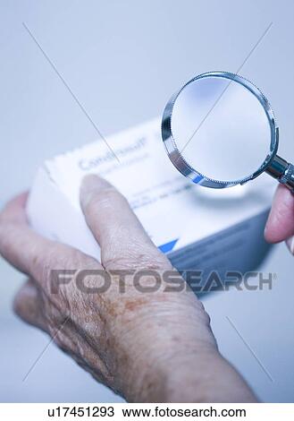 Stock Image - Checking drug packaging. Fotosearch