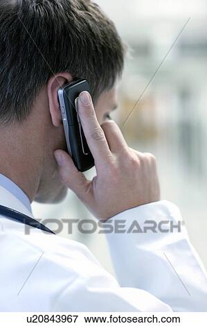 Stock Photo - Doctor talking on a mobile phone. Fotosearch