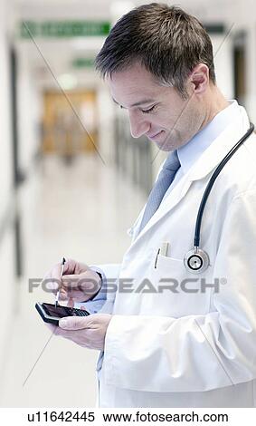 Doctor using a smart phone View Large Photo Image Stock Photography - Doctor using a smart phone. Fotosearch