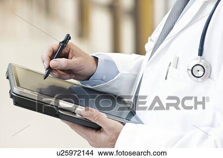 Doctor using a tablet PC View Large Photo Image Picture - Doctor using a tablet PC. Fotosearch