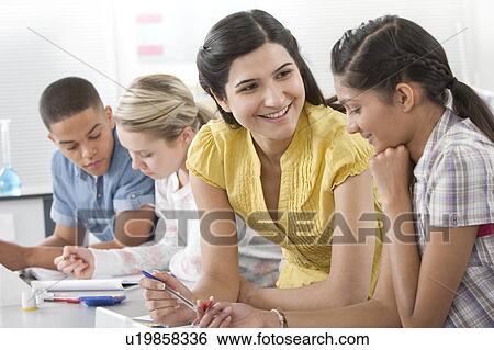 Teacher helping pupil View Large Photo Image Stock Photograph - Teacher helping pupil. Fotosearch