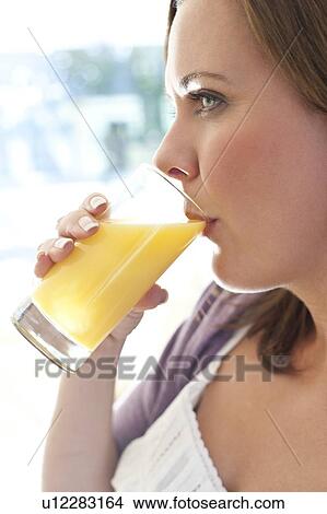 Picture - Woman drinking orange juice. Fotosearch