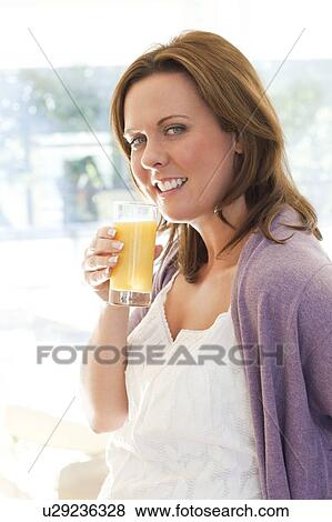 Stock Photo - Woman drinking orange juice. Fotosearch