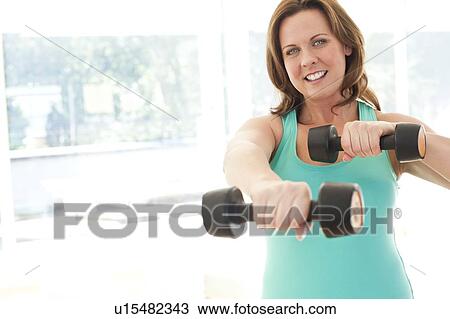 Woman lifting weights View Large Photo Image Stock Image - Woman lifting weights. Fotosearch