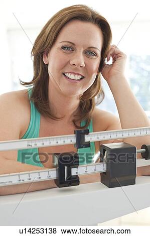 Stock Photo - Woman weighing herself. Fotosearch