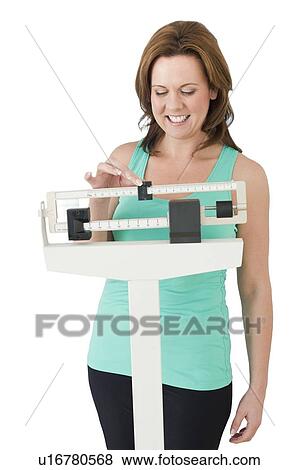 Woman weighing herself View Large Photo Image Stock Photo - Woman weighing herself. Fotosearch