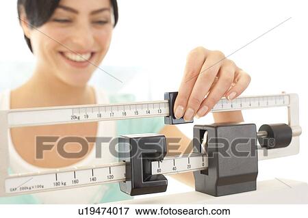 Woman weighing herself View Large Photo Image Stock Photo - Woman weighing herself. Fotosearch