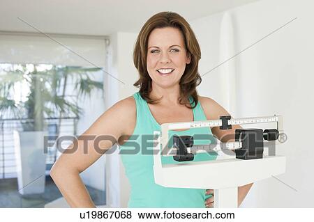 Woman weighing herself View Large Photo Image Stock Photo - Woman weighing herself. Fotosearch