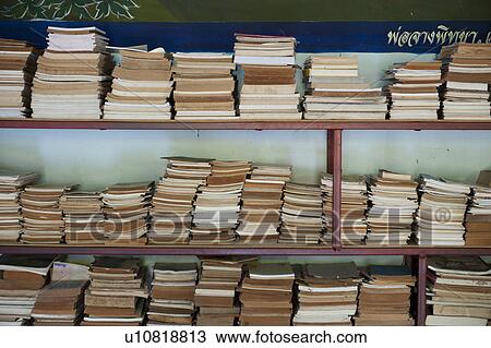 Stock Image - Books in a shelf in Wat Chong Kham temple, Mae Hong Son Province, Thailand. Fotosearch
