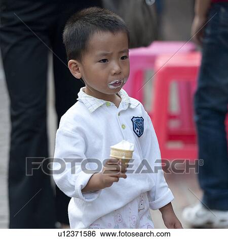 Stock Photograph - Boy licking an ice cream, Binhai, Tianjin, China. Fotosearch