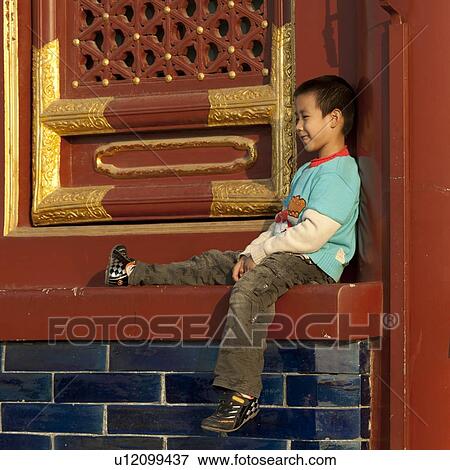 Stock Photo - Boy sitting at the Hall Of Prayer For Good Harvests at the Temple Of Heaven, Beijing, China. Fotosearch
