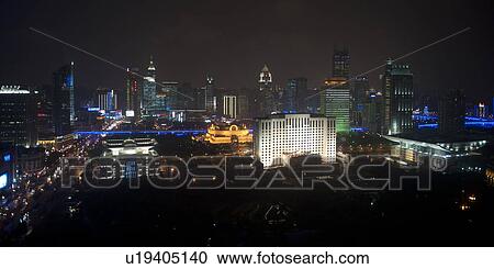 Stock Image - Buildings in a city lit up at night, Shanghai, China. Fotosearch