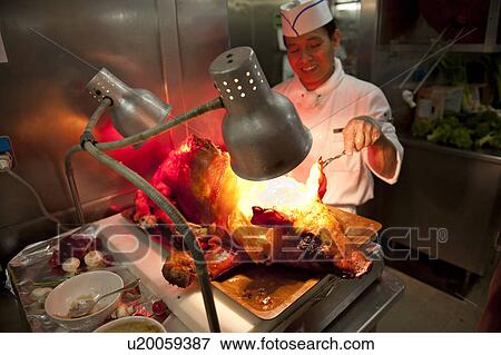 Stock Photo - Chef preparing pork in kitchen of a cruise ship Silver Shadow, East China Sea. Fotosearch