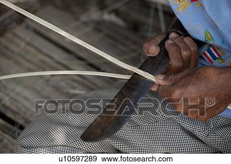 Stock Photo - Close-up of a person splitting bamboo strips, Chiang Dao, Chiang Mai Province, Thailand. Fotosearch
