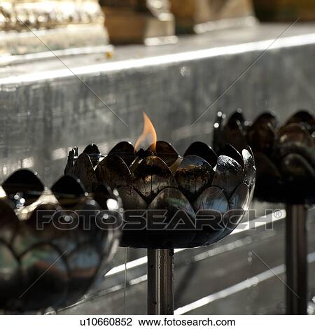 Stock Image - Close-up of oil lamps burning at Wat Phrathat Doi Suthep, Chiang Mai, Thailand. Fotosearch