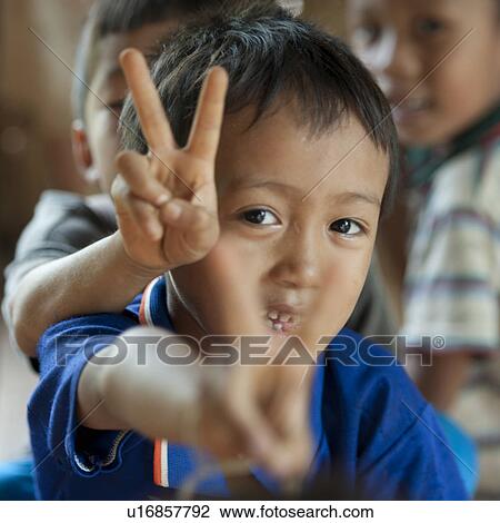 Stock Image - Close-up of Padaung boys showing V sign, Huay Pu Keng, Mae Hong Son Province, Thailand. Fotosearch