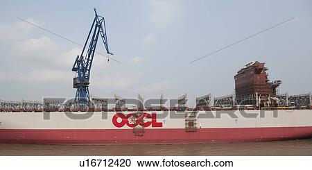 Stock Image - Container ship at a commercial dock, Yangtze River, Shanghai, China. Fotosearch
