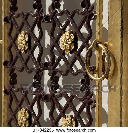 Stock Photography - Door knocker at a gate of Mandarin Oriental Dhara Dhevi, Chiang Mai, Thailand. Fotosearch