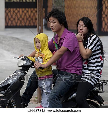 Stock Image - Family riding a scooter, Shanghai, China. Fotosearch