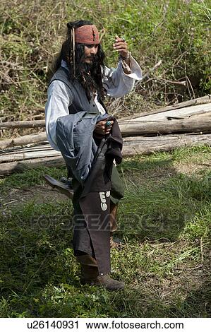 Stock Image - Man holding clothes in a field, Thailand. Fotosearch