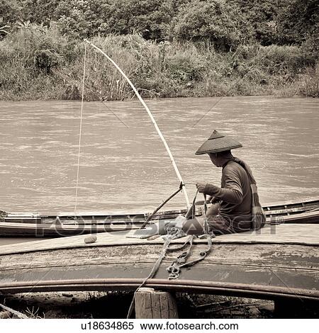 Stock Photography - Man repairing a boat, Thailand. Fotosearch
