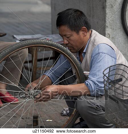 Man repairing bicycle tire, Shanghai, China View Large Photo Image Stock Image - Man repairing bicycle tire, Shanghai, China. Fotosearch