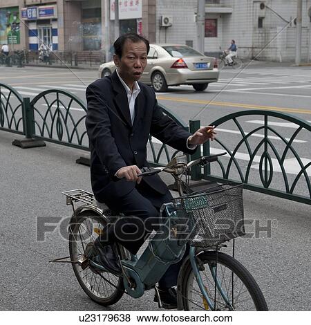 Stock Photo - Man riding a bicycle, Shanghai, China. Fotosearch