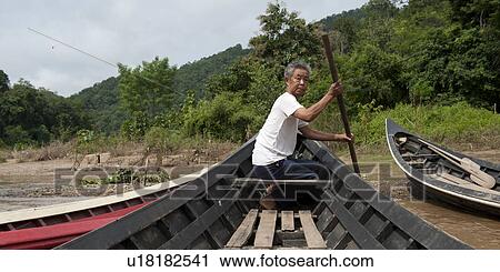 Man rowing a boat in the river, Thailand View Large Photo Image Stock Image - Man rowing a boat in the river, Thailand. Fotosearch