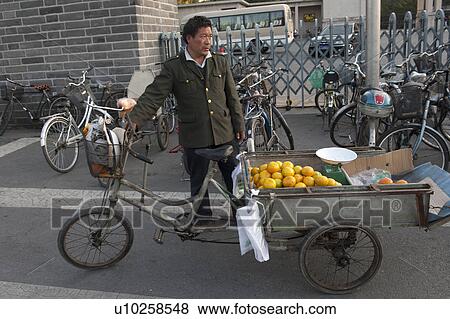 Stock Photo - Man selling oranges at a street, Beijing, China. Fotosearch
