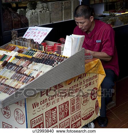 Stock Image - Man sitting at a tattoo shop, Shanghai, China. Fotosearch