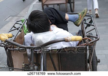 Stock Photo - Man sitting in a pedicab, Shanghai, China. Fotosearch