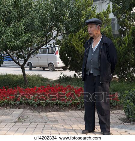 Picture - Man standing in a garden, Binhai, Tianjin, China. Fotosearch