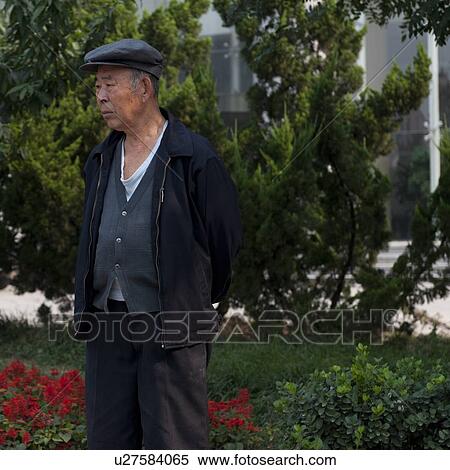 Stock Photography - Man standing in a garden, Binhai, Tianjin, China. Fotosearch