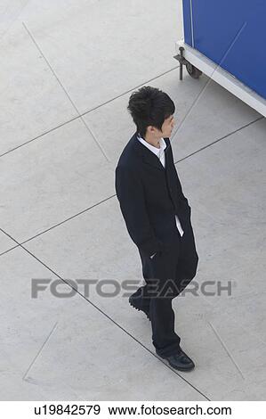 Stock Photo - Man walking on the street, Binhai, Tianjin, China. Fotosearch