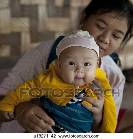 Stock Image - Padaung woman with her baby, Huay Pu Keng, Mae Hong Son Province, Thailand. Fotosearch