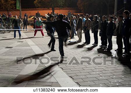 Stock Image - People playing feather kicker hacky sack, Back Lakes, Beijing, China. Fotosearch