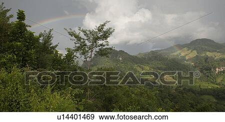 Stock Photo - Rainbow over a mountain range, Thailand. Fotosearch