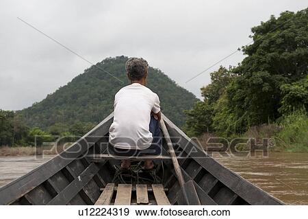 Rear view of a man sitting on a boat, Thailand View Large Photo Image Stock Photo - Rear view of a man sitting on a boat, Thailand. Fotosearch