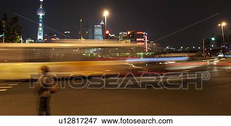 Stock Photo - Street scene at night with Oriental Pearl Tower in the background, The Bund, Pudong, Shanghai, China. Fotosearch