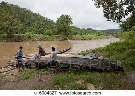 Stock Photo - Three men repairing a boat, Thailand. Fotosearch