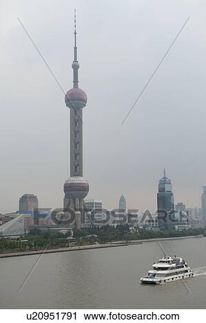 Stock Image - Tourboat with the Oriental Pearl Tower in the background, Pudong, Shanghai, China. Fotosearch