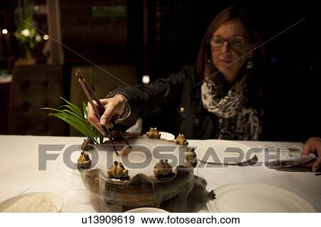 Woman eating food in a restaurant, Back Lakes, Beijing, China View Large Photo Image Stock Photo - Woman eating food in a restaurant, Back Lakes, Beijing, China. Fotosearch