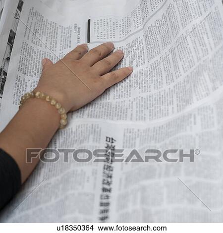 Picture - Woman reading a newspaper, Shanghai, China. Fotosearch
